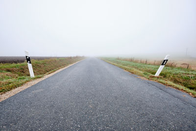 Road passing through landscape against clear sky