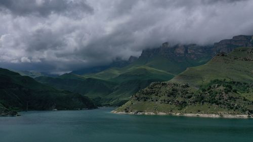 Scenic view of sea and mountains against sky