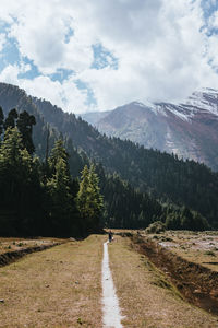 Road amidst field against sky