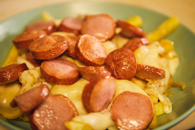 Close-up of food, wurstel with mayo and fried chips, fast food