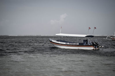 Boat sailing on sea against sky