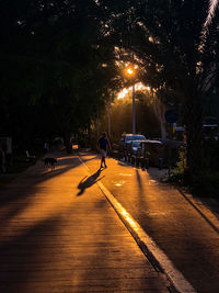 Man walking on illuminated street at night