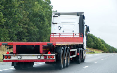 Red truck on road against sky