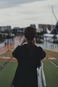 Rear view of woman standing against sky