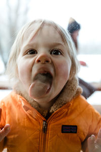 3 year old toddler girl smashes her tongue and face against window