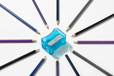 High angle view of colored pencils against white background