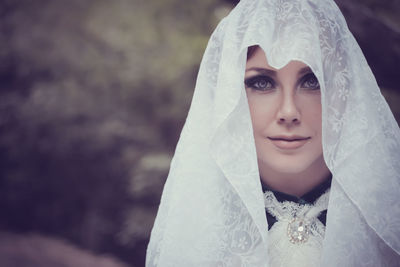 Portrait of bride wearing veil outdoors