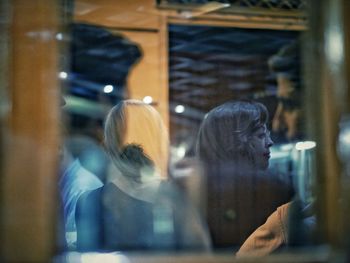 Portrait of woman looking through glass window