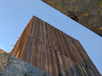 Wooden structure seen against blue sky in a mirror on the ground