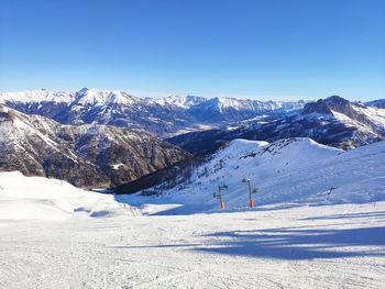 Scenic view of snowcapped mountains against blue sky