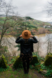 Rear view of a woman standing by douro river against sky