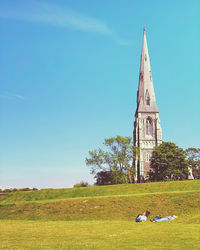 Traditional windmill on field against blue sky