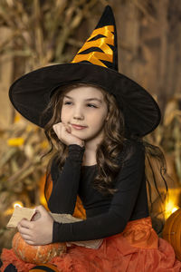 Portrait of young woman wearing hat while sitting on field