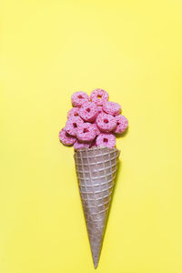 High angle view of ice cream cone against yellow background