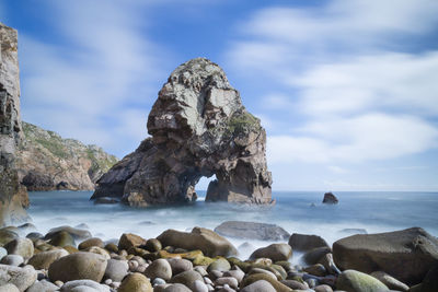 Natural rocky arch at calm sea
