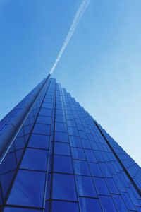 Low angle view of skyscraper against blue sky
