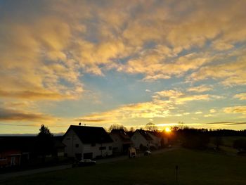 Houses against sky during sunset