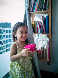 Toddler girl playing toy kitchen at home.