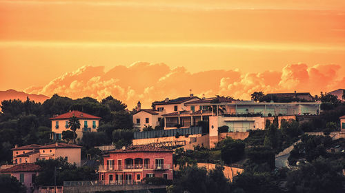 Buildings in town against sky during sunset