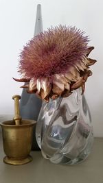 Close-up of vase on table against wall