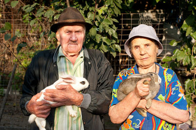 Close-up of senior couple with rabbits