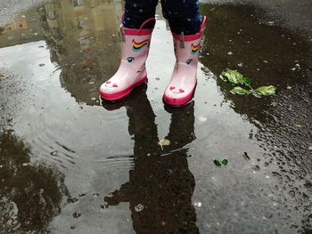 Low section of man standing on puddle