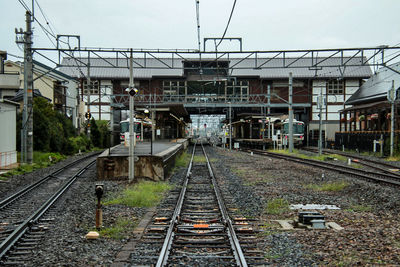 Railroad tracks by buildings against sky