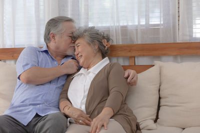 Midsection of couple sitting on sofa