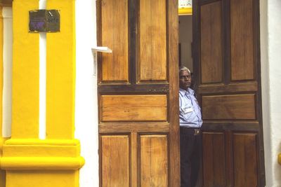 Portrait of security guard standing amidst door