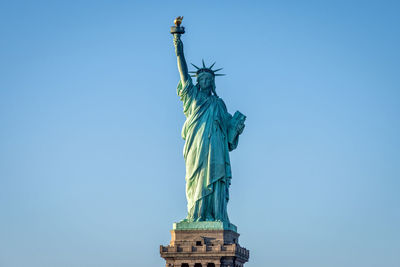 Low angle view of statue of liberty against clear blue sky