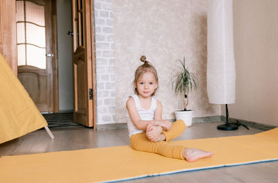 Portrait of smiling girl sitting on floor at home