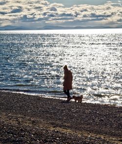 Rear view of shirtless man standing on beach