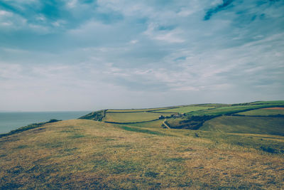 Scenic view of land and sea against sky