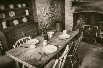 Empty chairs and table against wall