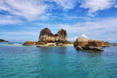 Panoramic view of rock formation in sea against sky