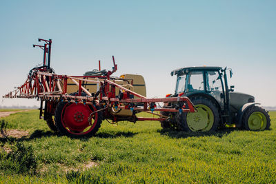 Tractor on field against clear sky