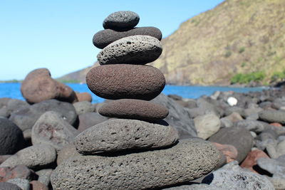 Close-up of stones on rocks against sky