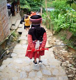 Rear view of woman walking on footpath