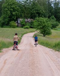 Rear view of man riding bicycle on road