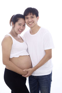 Portrait of smiling young couple against white background