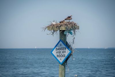 Information sign in a sea against clear sky