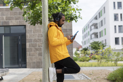 Full length of man using mobile phone in building