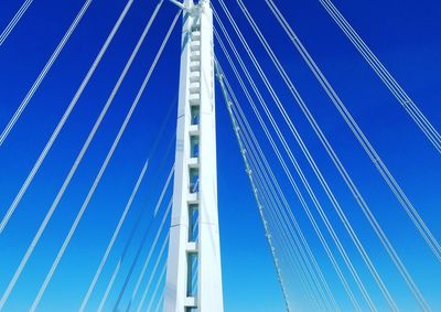 Low angle view of suspension bridge against clear blue sky