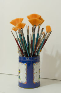 Close-up of multi colored jar on table against wall