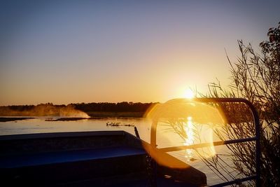 Scenic view of lake against clear sky during sunset