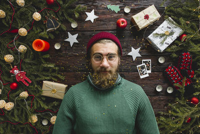 Portrait of man amidst christmas decorations on table