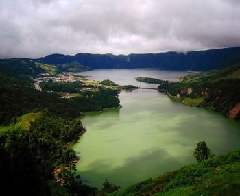 High angle view of lake against mountains and cloudy sky