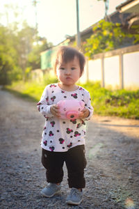 Portrait of cute girl standing on road