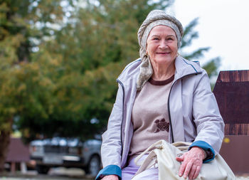 An old woman is smiling. portrait of a happy woman on a city background.