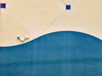 Low angle view of balloons against blue wall